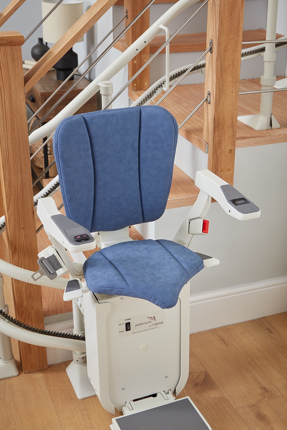 Image of a Platinum Ergo Curve stairlift at the bottom of the stairs