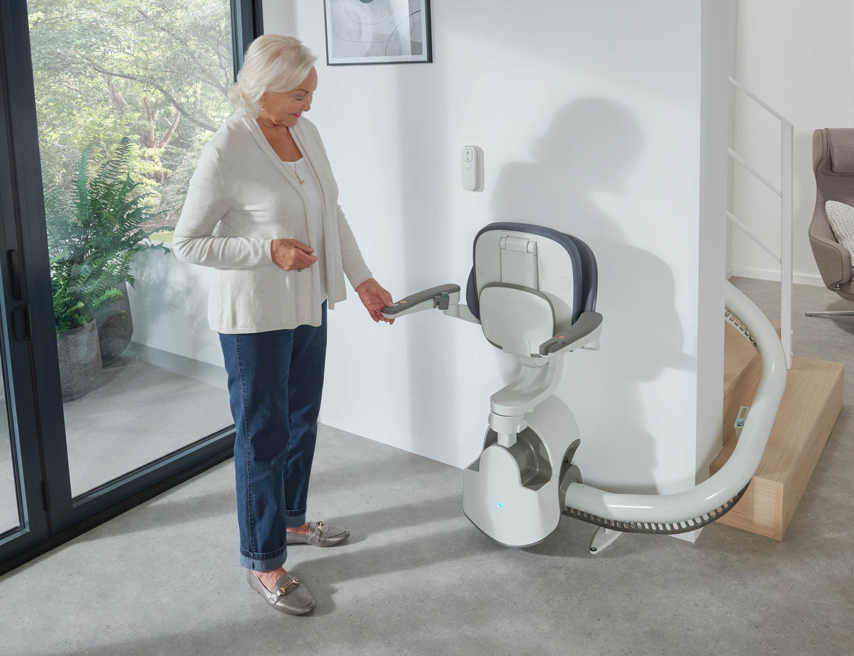 Image of a woman walking to a FlowX Curved stairlift