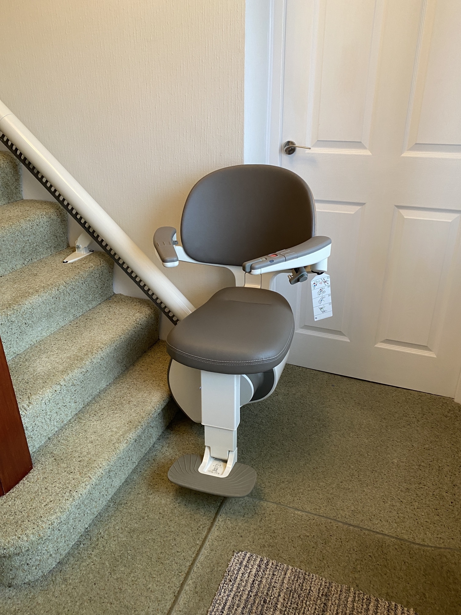 Image of a FlowX Curved stairlift at the bottom of the stairs