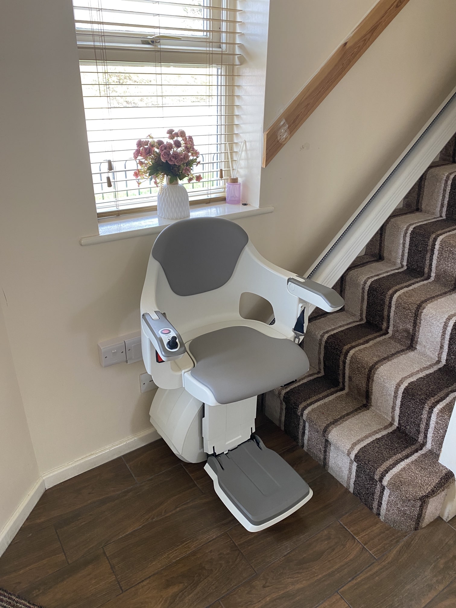 Image of a HomeGlide stairlift at the bottom of the stairs.